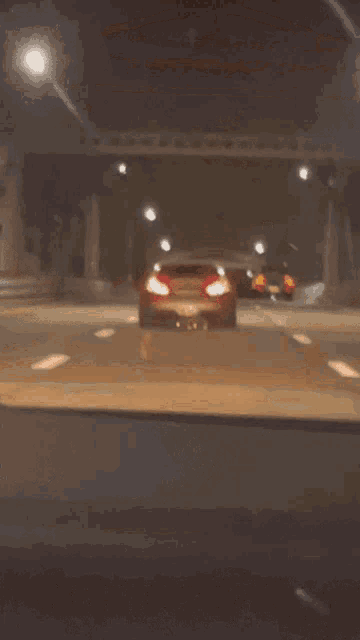 a blurred image of a car driving down a road at night