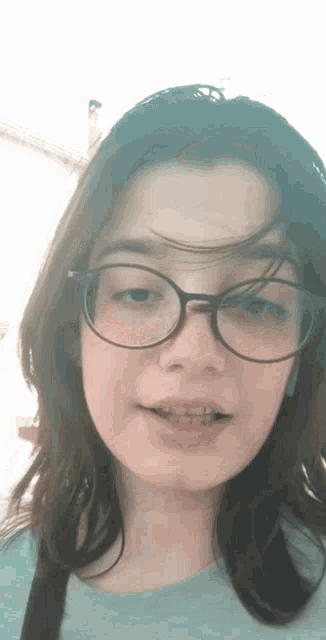 a girl wearing glasses and braces is making a funny face