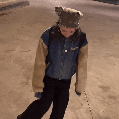 a person wearing a mickey mouse jacket walking on a sidewalk
