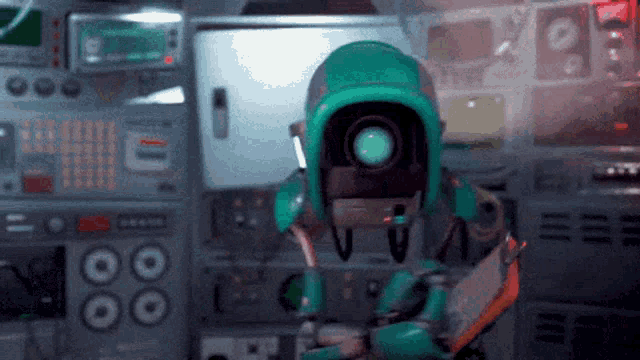 a robot in a green helmet is standing in front of a control panel holding a tablet .