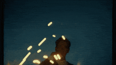 a man in a suit lighting a cigarette with a lot of lights coming out of it