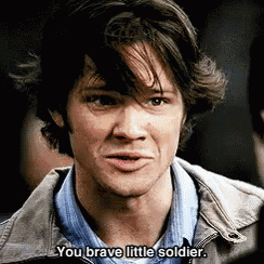 a man in a jacket is talking to another man and says `` you brave little soldier '' .