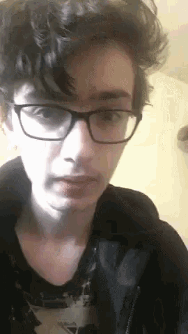 a close up of a person wearing glasses and a black jacket .