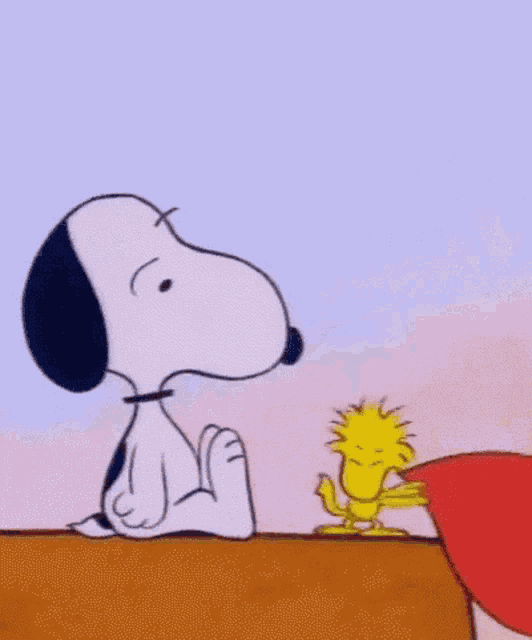 snoopy is holding a heart in his mouth and woodstock is holding a heart in his hand .