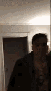 a man is standing in a dark room with a green screen in front of him .