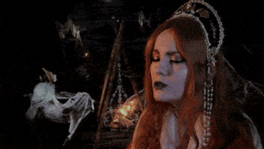 a woman with red hair is wearing a headband with pearls on it
