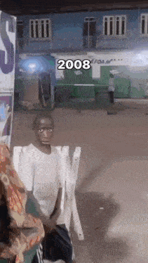 a young boy is sitting in a chair with the year 2008 on the bottom