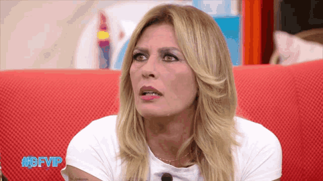 a woman sitting on a red couch with the hashtag #gfvip on the bottom