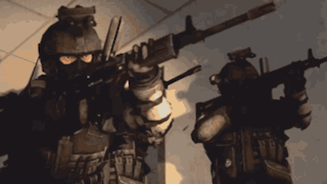 two soldiers are standing next to each other holding guns in a room .