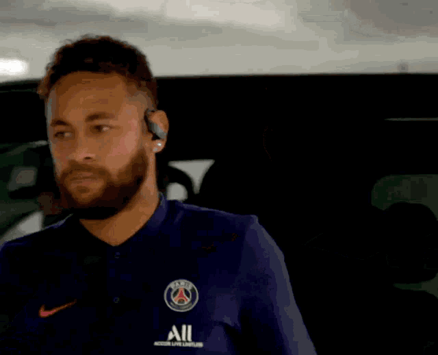 a man with a beard wearing a blue shirt that says all on it