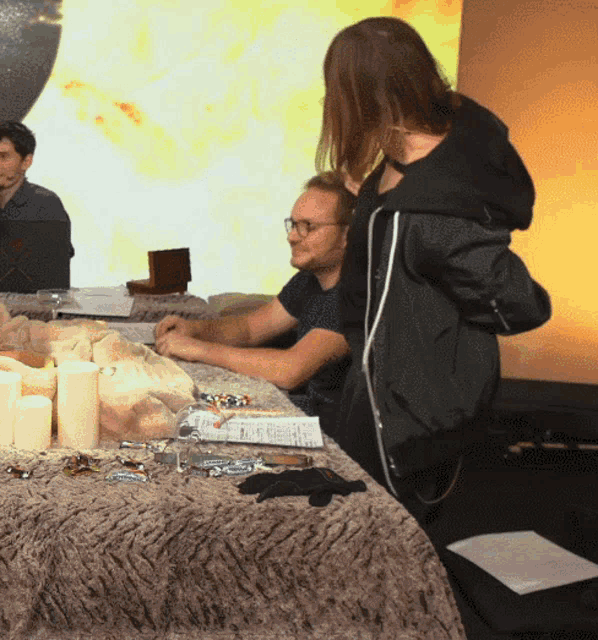 a man and a woman sit at a table with candles