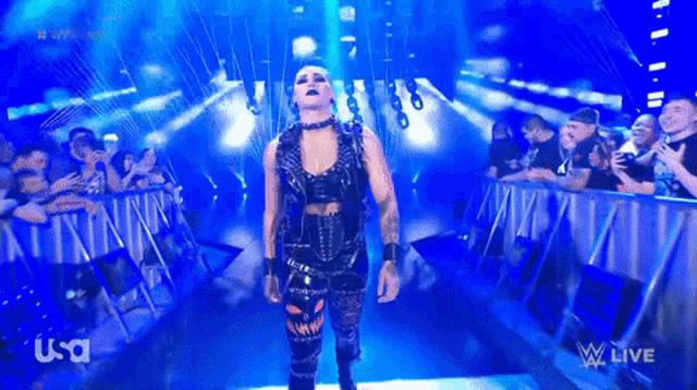 a female wrestler is walking into a ring with a usa logo on the bottom right