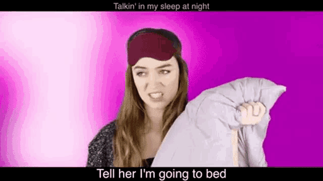 a woman wearing a sleep mask is holding a pillow and talking to her .