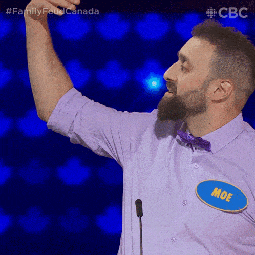 a man in a purple shirt with a name tag that says moe