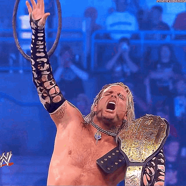 a shirtless wrestler is holding a world heavyweight championship