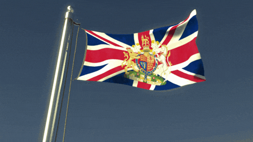 a british flag with a coat of arms on it is flying in the wind
