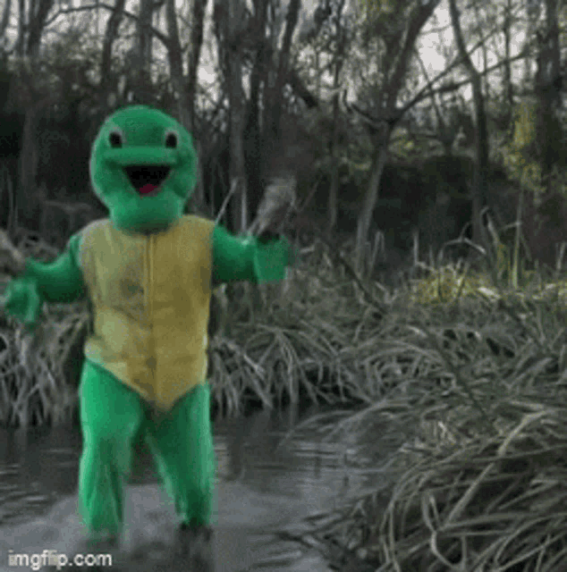a green turtle mascot is dancing in the water