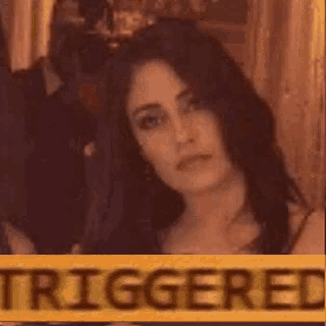 a woman is standing next to a yellow sign that says `` triggered '' .