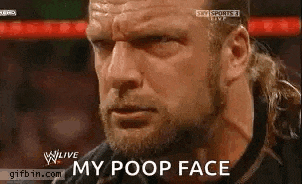a man with a beard is making a funny face while watching a wrestling match .