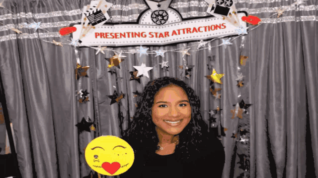 a woman is standing in front of a sign that says presenting star attractions
