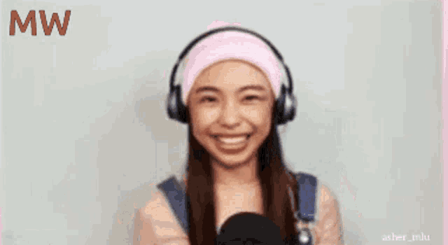 a woman wearing headphones and a pink headband with the letters mw on the bottom