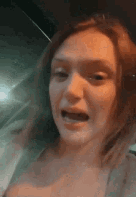 a close up of a woman 's face with her mouth open and headphones on .