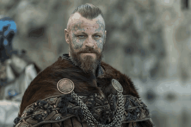 a man with a beard and a tattoo on his face