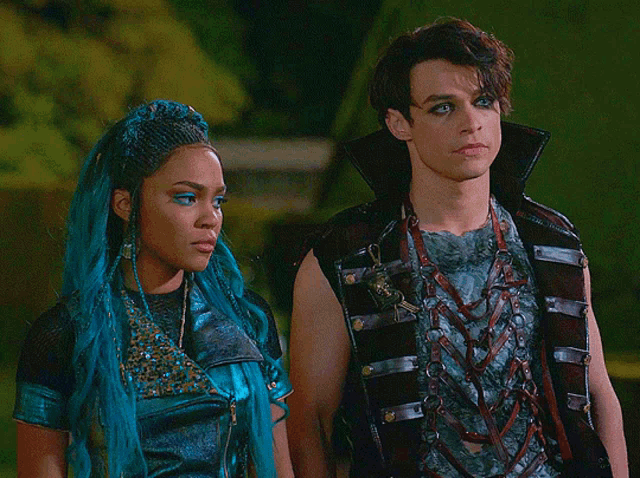 a man and a woman are standing next to each other and the woman has blue hair