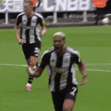 a soccer player wearing a black and white jersey with the number 7 on it