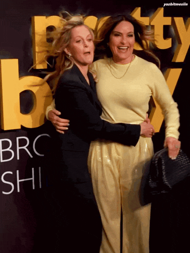 two women hug in front of a sign that says brc shi