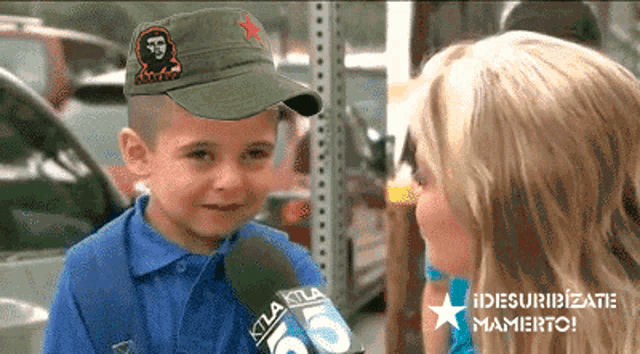 a young boy wearing a che guevara hat is talking to a woman