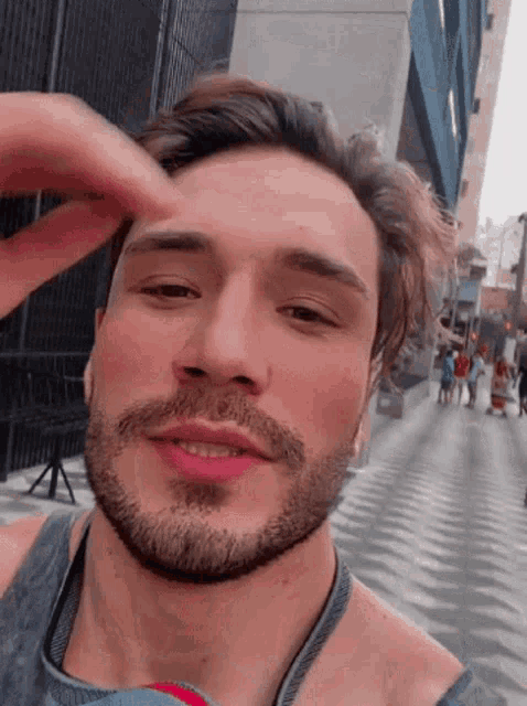 a man with a beard is touching his head