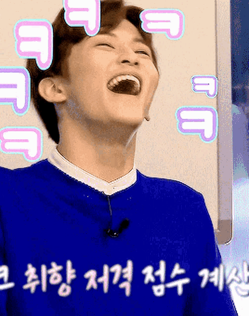 a man wearing a blue sweater is laughing with pink letters around his face