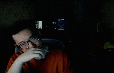 a man wearing glasses is sitting in front of a computer screen