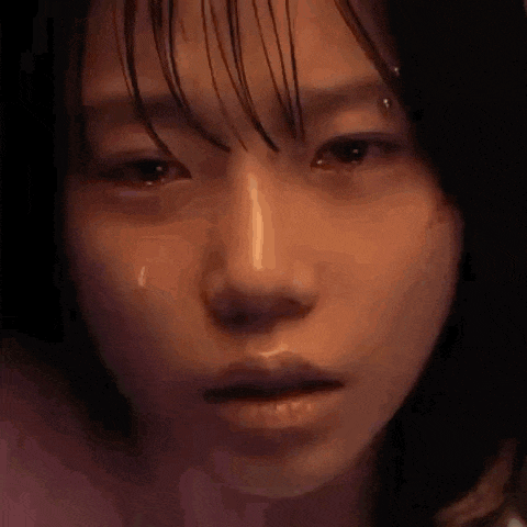 a close up of a woman 's face with a tear running down her eye .
