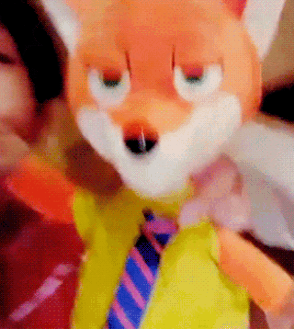 a stuffed fox with a yellow shirt and tie