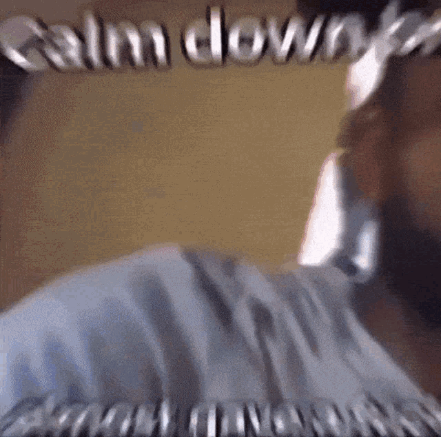 a blurry picture of a man with the words calm down written on the bottom