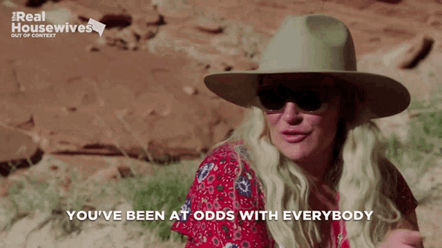 a woman wearing a hat and sunglasses with the words " you 've been at odds with everybody " below her