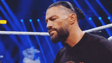 a man with a beard is in a wrestling ring .