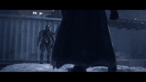 a man in a batman mask looks at the camera