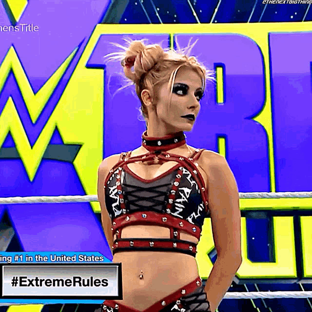 a woman is standing in a wrestling ring with a sign that says #extremerules