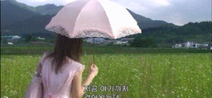 a woman in a pink dress is holding a pink umbrella in a field