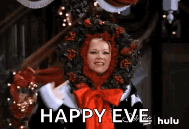 a woman wearing a santa hat and a wreath on her head is standing in front of a christmas tree .