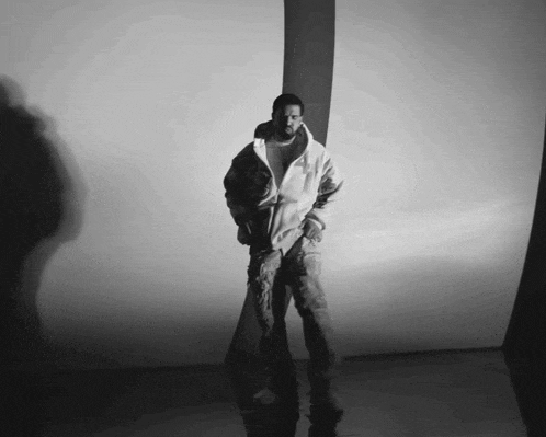 a black and white photo of a man wearing a white jacket