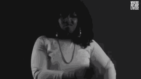 a woman is dancing in a black and white photo .