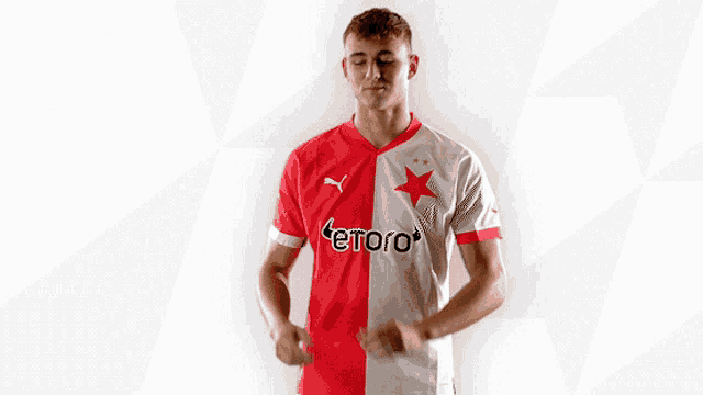 a man is wearing a red and white jersey with the word etoro on it