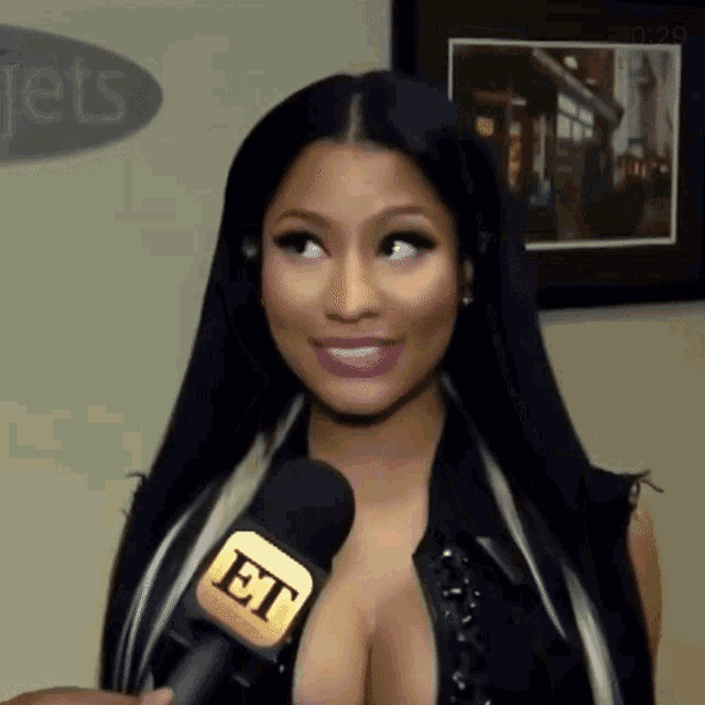 a woman is talking into an et microphone