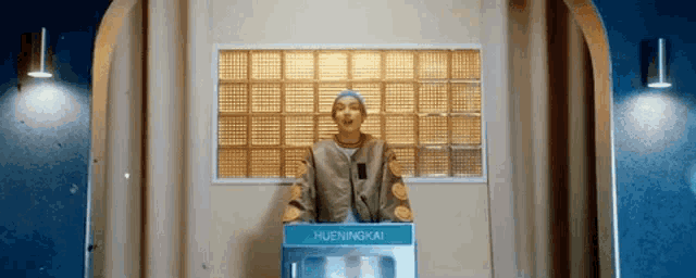 a man is standing in front of a microwave oven in a room .