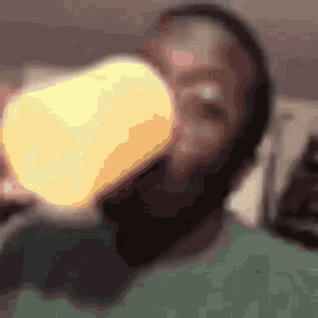 a blurry picture of a man drinking from a glass