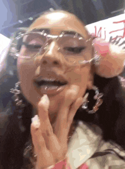 a close up of a woman wearing glasses and hoop earrings